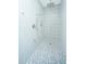 Modern walk-in shower with gray mosaic tile floor and raindrop showerhead, complemented by white brick walls at 810 Highway 61, Ridgeville, SC 29472