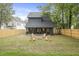 View of the backyard with a modern home, new wooden fence, and fire pit area with Adirondack chairs at 868 Tripe St, Charleston, SC 29407