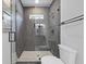 Modern bathroom featuring a glass shower with gray tile, a white toilet, and a window for natural light at 868 Tripe St, Charleston, SC 29407