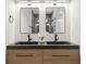 Bathroom vanity with double sinks, wood cabinets, matte black fixtures, decorative flowers and dual mirrors at 868 Tripe St, Charleston, SC 29407