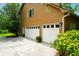 Two car garage with white doors, mature landscaping, and a paved driveway at 919 Overview Ct, Mount Pleasant, SC 29464