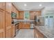 Well-lit kitchen with stainless steel appliances and wood cabinets offer ample storage at 9646 Scarborough Ct, Summerville, SC 29485