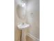 A pedestal sink and a round mirror add elegance to the powder room at 9646 Scarborough Ct, Summerville, SC 29485