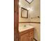 Cozy powder room featuring classic floral wallpaper, a wood-framed mirror and light wood vanity at 103 Kenninghall Rd, Goose Creek, SC 29445