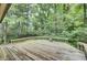 Wood deck with wood railing overlooks lush, green, and dense backyard foliage at 103 Kenninghall Rd, Goose Creek, SC 29445
