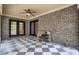 Spacious brick patio with checkered floors, ceiling fan, and double French doors, perfect for outdoor relaxation at 103 Kenninghall Rd, Goose Creek, SC 29445