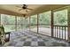 Large screened porch with checkered floors, ceiling fan, and door leading to the wood deck at 103 Kenninghall Rd, Goose Creek, SC 29445