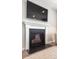 Close-up of a modern fireplace with white mantel, black surround, and mounted television above at 104 Orchard Blossom Ln, Summerville, SC 29485