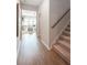 Inviting hallway with hardwood floors, a staircase, and an open view into a well-lit living area at 104 Orchard Blossom Ln, Summerville, SC 29485