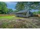 Fenced backyard featuring a detached garage, mature trees, and a mix of grassy and bare areas at 105 Glebe Rd, Summerville, SC 29485