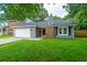 Charming single-story home featuring a well-manicured lawn, attached garage and brick chimney at 105 Glebe Rd, Summerville, SC 29485