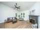 Bright living room featuring new hardwood floors, a ceiling fan, large windows, and a fireplace at 105 Glebe Rd, Summerville, SC 29485