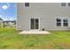 Exterior shot of backyard featuring a concrete patio, green grass, grey siding, and sliding glass doors at 105 Oast Ln, Summerville, SC 29485