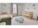 Charming Bedroom featuring a wooden crib, changing table, and a decorative leaf-shaped rug on neutral carpet at 105 Oast Ln, Summerville, SC 29485