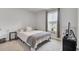 Well-lit bedroom boasts a comfortable bed with a gray throw blanket and a window with backyard view at 105 Oast Ln, Summerville, SC 29485