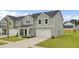 Charming two-story home with gray siding, a white garage door, and a well-manicured lawn at 105 Oast Ln, Summerville, SC 29485