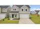 Charming two-story home with gray siding, a white garage door, and a well-manicured lawn at 105 Oast Ln, Summerville, SC 29485