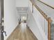 Bright hallway featuring wood floors and a staircase with wooden handrails at 105 Oast Ln, Summerville, SC 29485