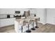 Modern kitchen with an island, bar stools, stainless steel appliances, and wood flooring at 105 Oast Ln, Summerville, SC 29485