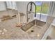 Bright kitchen island featuring a stainless steel sink, granite countertop and views of the backyard at 105 Oast Ln, Summerville, SC 29485