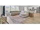 Sunlit living room featuring a comfortable sectional sofa, decorative rug, and wood flooring at 105 Oast Ln, Summerville, SC 29485