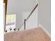 Bright staircase landing with carpeted steps, white railing and large window for natural light at 105 Oast Ln, Summerville, SC 29485