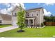 A tan two-story home with an attached garage and a green lawn at 111 Nolin Road Rd, Moncks Corner, SC 29461