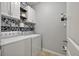 Well-equipped laundry room with washer, dryer, and overhead cabinets with decorative wallpaper at 111 Nolin Road Rd, Moncks Corner, SC 29461