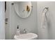 Cozy powder room with pedestal sink, decorative mirror, and neutral color scheme at 111 Nolin Road Rd, Moncks Corner, SC 29461