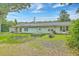 Exterior rear of home showing a spacious backyard with lush green grass and garden beds at 1314 Cooper Store Rd, Moncks Corner, SC 29461