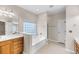 Bright bathroom with a soaking tub, window, tiled floor, and wooden vanity with double sinks at 1445 Ashley Gardens Blvd, Charleston, SC 29414