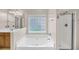 Bathroom showcasing a soaking tub with window, walk-in shower, and a wood vanity with sink at 1445 Ashley Gardens Blvd, Charleston, SC 29414