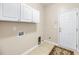 Functional laundry room equipped with overhead cabinets, tile flooring, and a utility sink at 1445 Ashley Gardens Blvd, Charleston, SC 29414