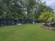 Spacious backyard featuring lush green grass, mature trees, privacy fence, and playhouse at 1489 Red Tide Rd, Mount Pleasant, SC 29466