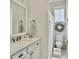Bright bathroom with a white vanity, toilet and white tile flooring at 1489 Red Tide Rd, Mount Pleasant, SC 29466