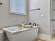 A modern white bathtub with black fixtures is situated under a window, offering a peaceful bathing experience at 1489 Red Tide Rd, Mount Pleasant, SC 29466