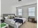 Bedroom with bed, decorated with unique throw pillows, flanked by side tables and bathed in natural light from two windows at 1489 Red Tide Rd, Mount Pleasant, SC 29466