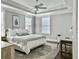 A serene bedroom featuring tray ceilings, neutral tones, and natural lighting at 1489 Red Tide Rd, Mount Pleasant, SC 29466