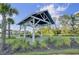 A covered picnic area in a landscaped community space, including picnic tables, lush trees, and green lawn at 1489 Red Tide Rd, Mount Pleasant, SC 29466