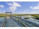 Picturesque wooden dock stretches into the serene marsh, offering peaceful waterfront access at 1489 Red Tide Rd, Mount Pleasant, SC 29466