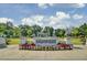 Inviting community entrance with the 'Brigade Hall' sign, complemented by colorful flowerbeds and American flags at 1489 Red Tide Rd, Mount Pleasant, SC 29466