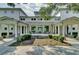 Inviting building entrance with stone accents, rocking chairs, and a well-manicured garden at 1489 Red Tide Rd, Mount Pleasant, SC 29466