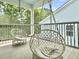 Cozy screened-in porch featuring two hanging egg chairs and views of the surrounding greenery at 1489 Red Tide Rd, Mount Pleasant, SC 29466