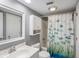 Well-lit bathroom featuring a white vanity, toilet, and shower with a fun, colorful fish-themed shower curtain at 1605 Live Oak Park, Seabrook Island, SC 29455