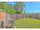 Private backyard with a green lawn, charcoal grill, chairs, and a wooden fence at 163 Spencer Cir, Summerville, SC 29485