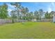 Large backyard offers lush green grass, a privacy fence, and play equipment at 184 Kirkland St, Goose Creek, SC 29445