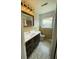 Bathroom with dark wood vanity, custom mirror and eye-catching light fixtures and unique tile flooring at 2 Clarksville Ln, Goose Creek, SC 29445