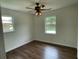 Bright bedroom with hardwood floors, ceiling fan, and windows offering natural light and outdoor views at 2 Clarksville Ln, Goose Creek, SC 29445