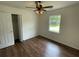 Bedroom features wood floors, a ceiling fan, closet, and a bright window offering outdoor views at 2 Clarksville Ln, Goose Creek, SC 29445