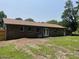 Rear exterior view of the brick home featuring a large backyard, and a mix of grass and bare ground at 2 Clarksville Ln, Goose Creek, SC 29445